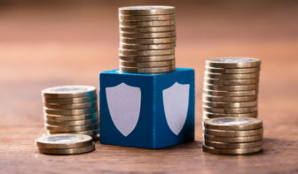 Stack Of Coins With Security Blocks On Wooden Block to illustrate high yield returns