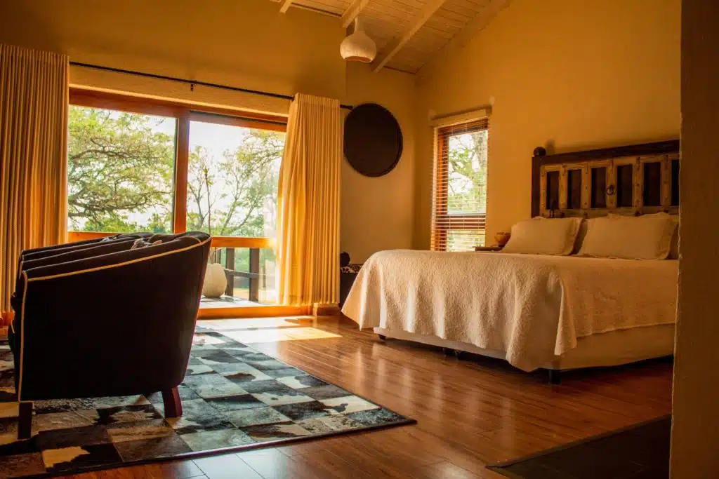 bedroom with a bed, armchair, and a sliding door leading to a deck