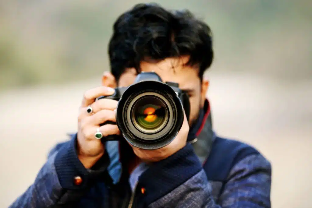 Photographer pointing his camera lens at the camera